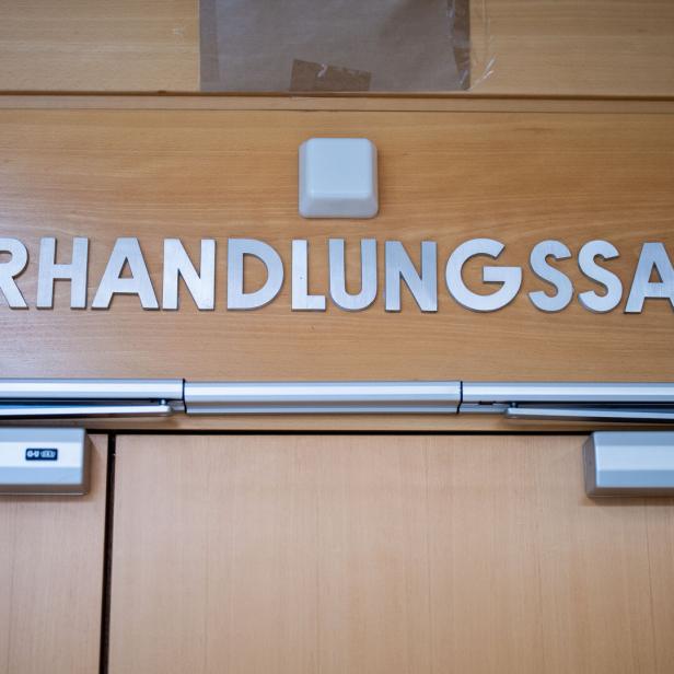 Über einer Holztür steht in großen silbernen Buchstaben das Wort „Verhandlungssaal“.