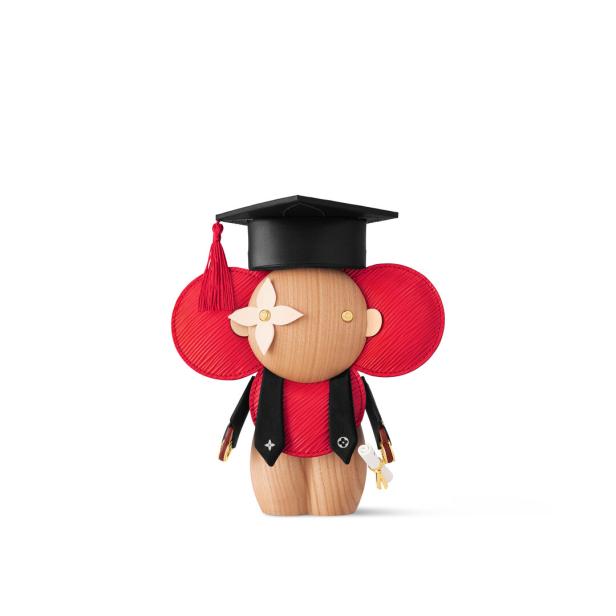 Eine Louis Vuitton Holzfigur in Form eines Absolventen mit Doktorhut und Diplom.
