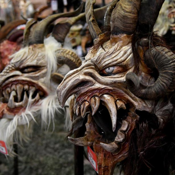 Nahaufnahme von Krampusmasken mit Hörnern und spitzen Zähnen.