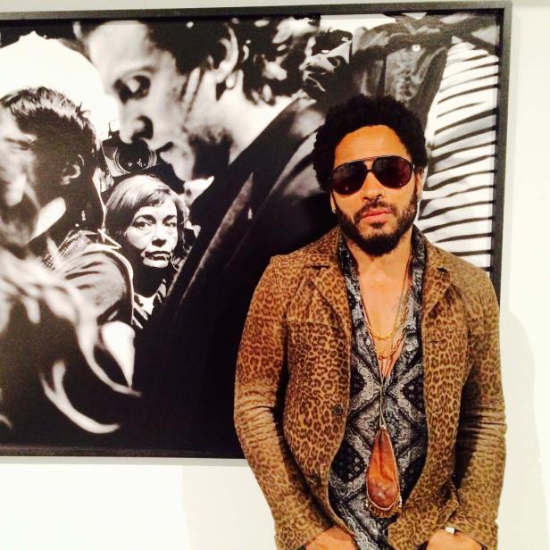 Lenny Kravitz posiert vor einem Schwarz-Weiß-Foto.