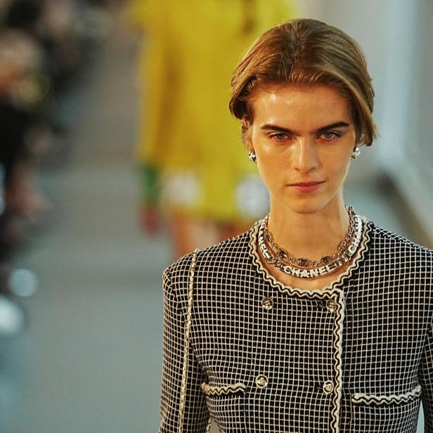 Ein Model auf dem Laufsteg trägt eine Jacke und eine Halskette von Chanel.