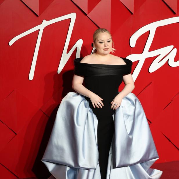 Nicola Coughlan in einem schwarzen Kleid mit hellblauer Schleppe auf dem roten Teppich.