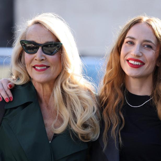 Zwei Frauen, eine mit Sonnenbrille, lächeln in die Kamera.
