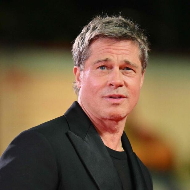 Brad Pitt in einem schwarzen Anzug auf einem roten Teppich.