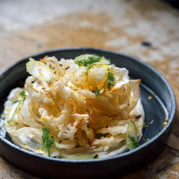 Frittierter Fenchel auf einer Creme, garniert mit Dill und Zitrone.