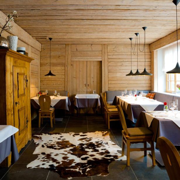 Innenansicht des Restaurants „Das Wolf“ mit Tischen und Holzeinrichtung.