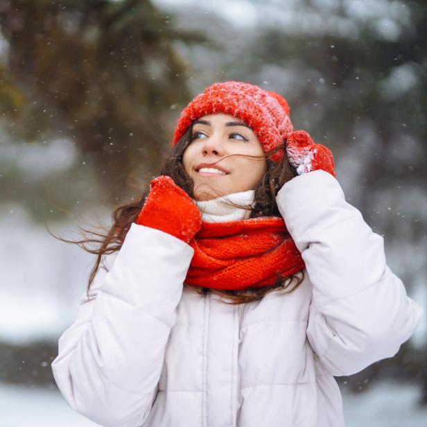Frau mit Schal und Mantel beim winterlichen Spaziergang.