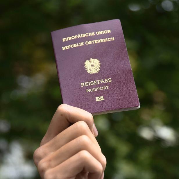 Eine Hand hält einen österreichischen Reisepass.