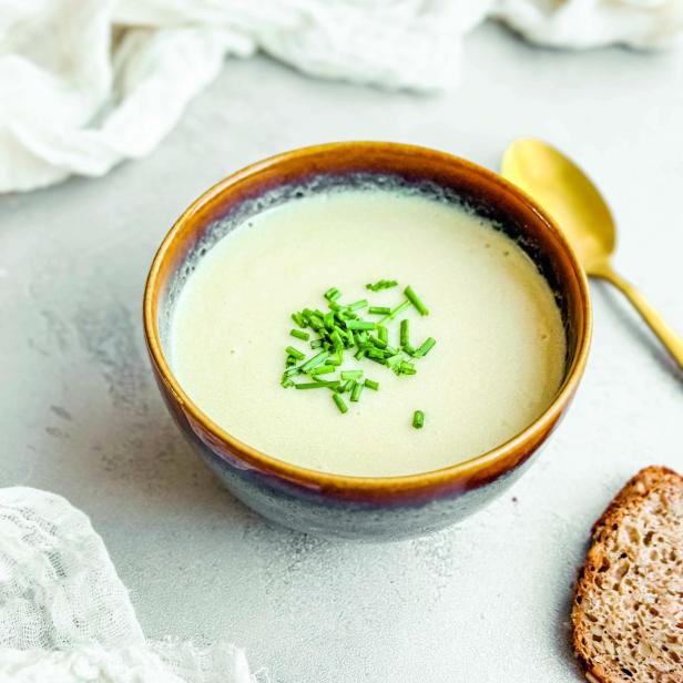 Pastinakencremesuppe mit Schnittlauch in einer braunen Schüssel.