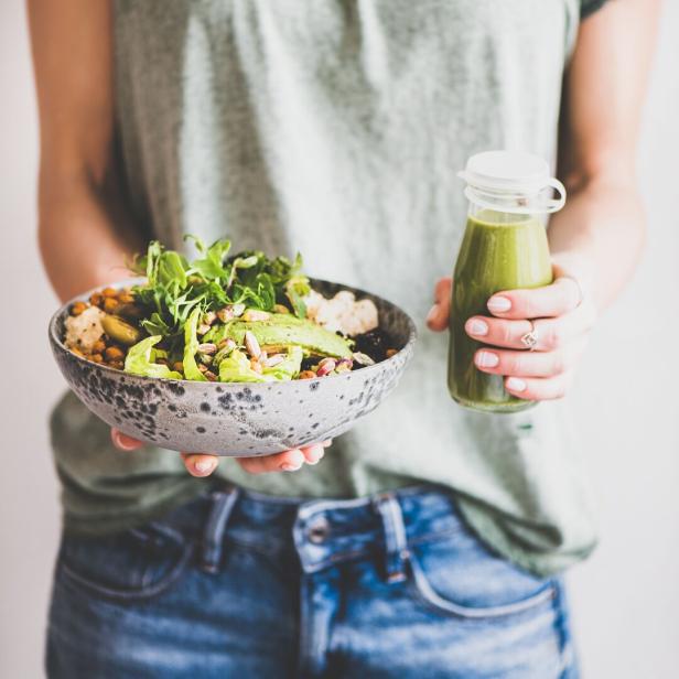Eine gesunde Bowl mit Hülsenfrüchten, Nüssen und Salat und ein Vitamin-C-Smoothie.