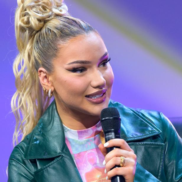 Shirin David hält ein Mikrofon in der Hand.