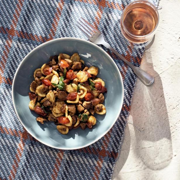 Pasta mit Lammragù, Tomaten und Rucola.