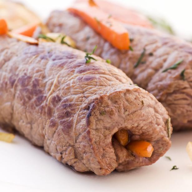 Zwei Rindsrouladen mit Karottenfüllung auf einem Teller.