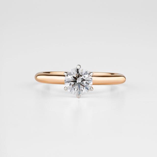 Ein goldener Verlobungsring mit einem kleinen Diamanten in der Mitte. 