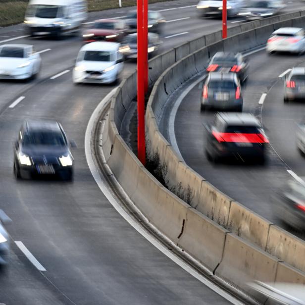 Eine Autobahn mit schnellfahrenden Autos, die verschwommen gezeigt werden. Beide Fahrtrichtungen sind zu sehen.