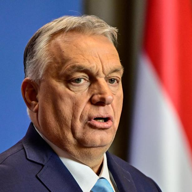 Viktor Orbán spricht vor der ungarischen Flagge.