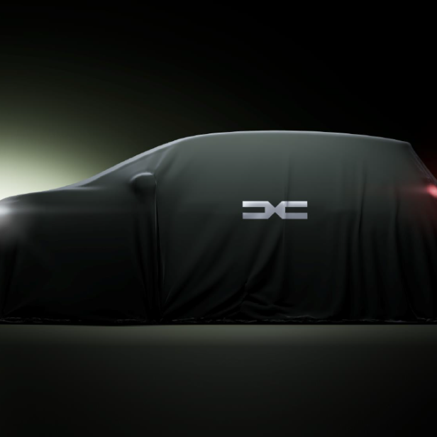 Ein Auto mit dem Dacia-Logo ist mit einem schwarzen Tuch abgedeckt.