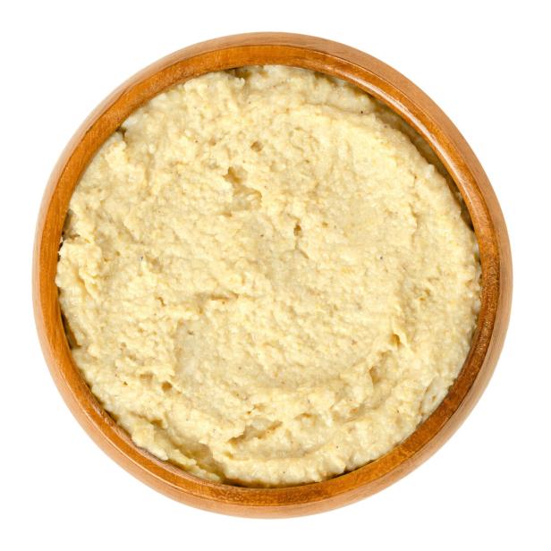 Ein Holzteller ist mit cremiger Polenta gefüllt.