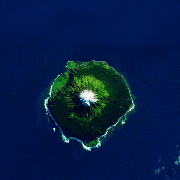 Luftaufnahme der Insel Tristan da Cunha mit schneebedecktem Vulkan.