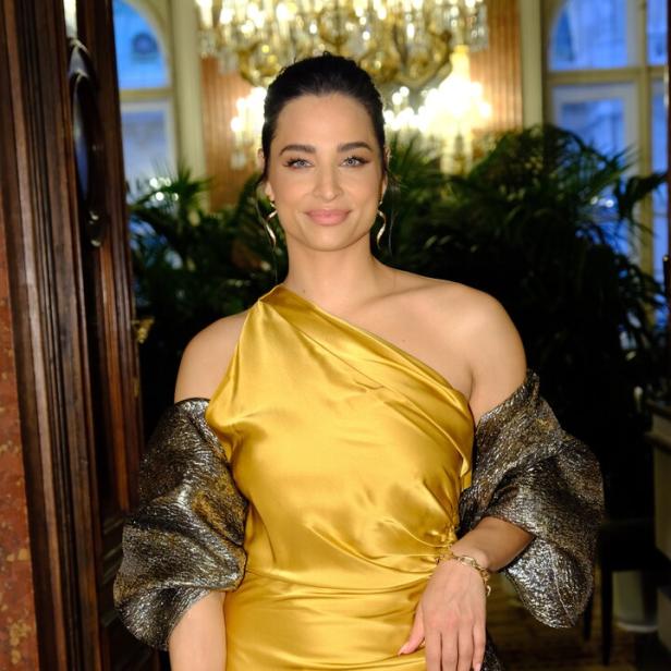 Amira Aly. Sie trägt ein goldenes Abendkleid.