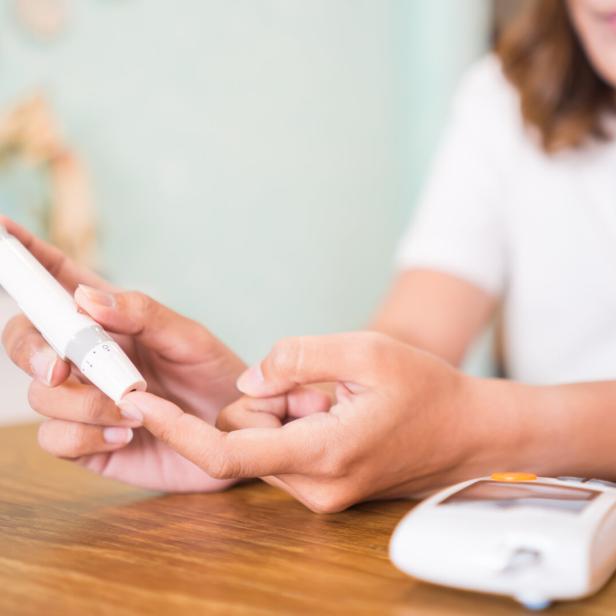 Eine Frau überprüft ihren Blutzuckerspiegel.