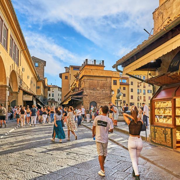 Menschen flanieren auf der Ponte Vecchio in Florenz.