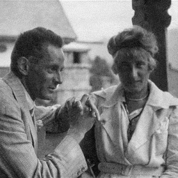 Ein Mann und eine Frau halten Hände, möglicherweise vor einem Haus.