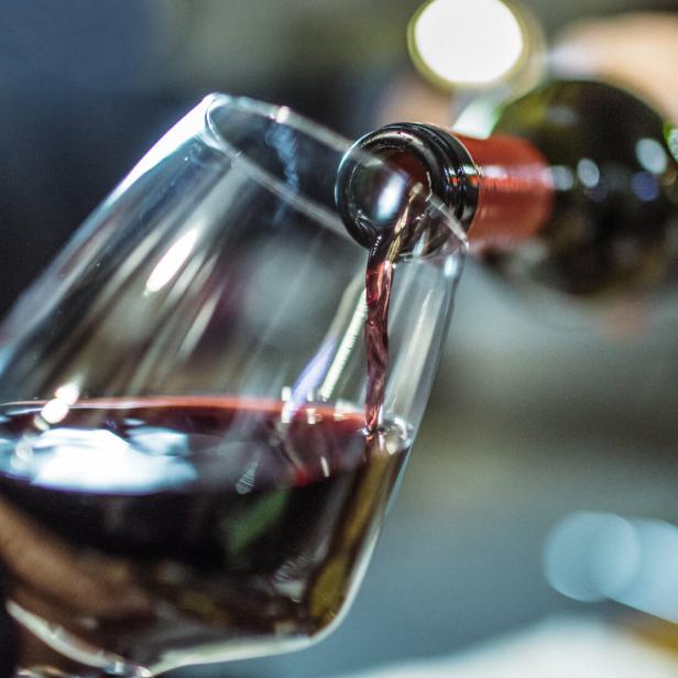Ein Glas Rotwein wird eingeschenkt.