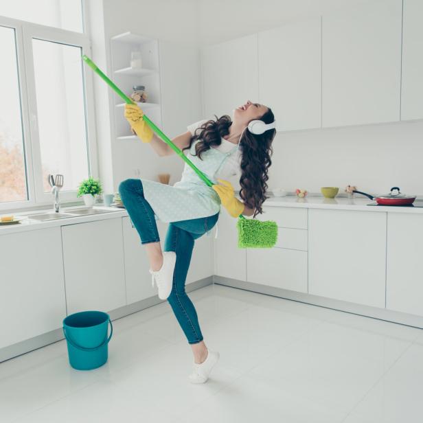 Frau putzt motiviert die Wohnung.
