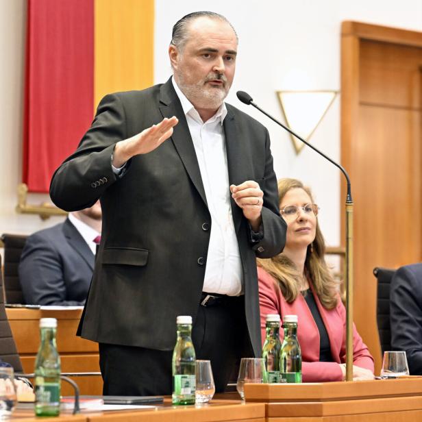 Ein Mann in einem Anzug spricht vor einem Publikum.