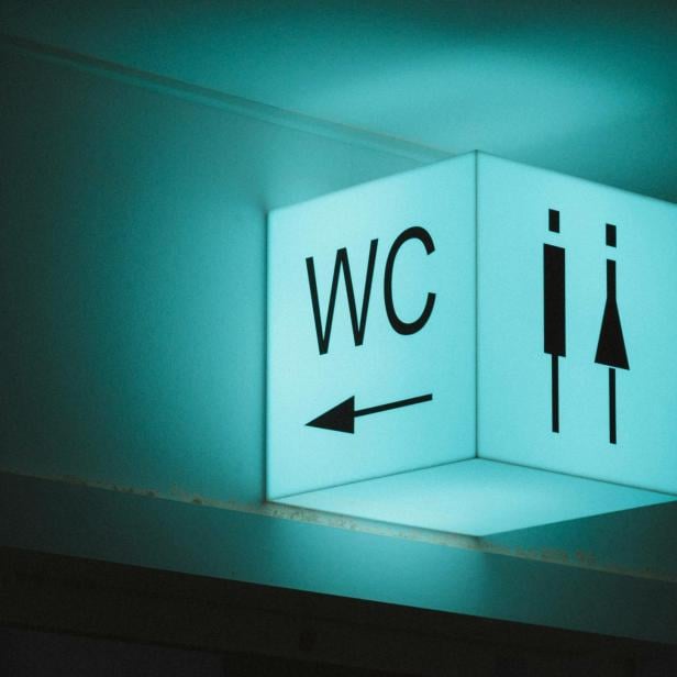 Leuchtendes Zeichen einer Flughafen-Toilette.
