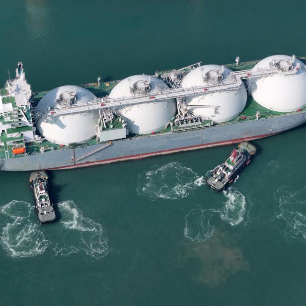LNG-Tanker wird von Schleppschiffen in einem Hafen manövriert
