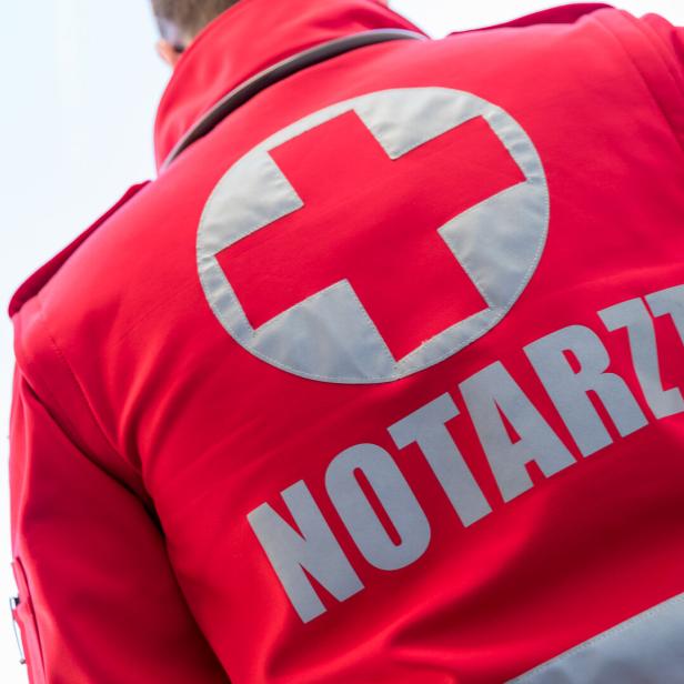 Ein roter Notarzt-Anzug mit einem weißen Kreuz ist von hinten zu sehen.
