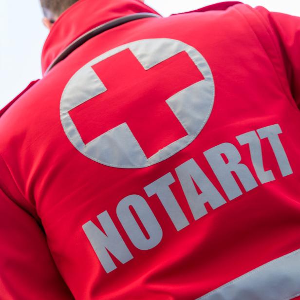 Ein roter Notarzt-Anzug mit einem weißen Kreuz ist von hinten zu sehen.