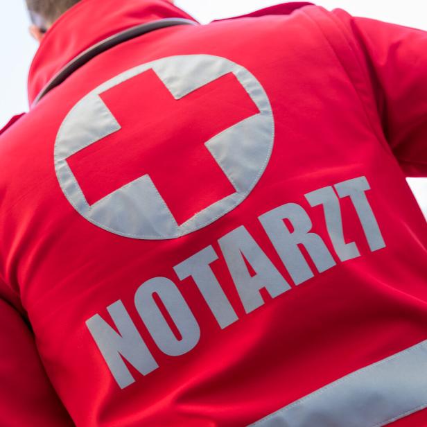 Ein roter Notarzt-Anzug mit einem weißen Kreuz ist von hinten zu sehen.