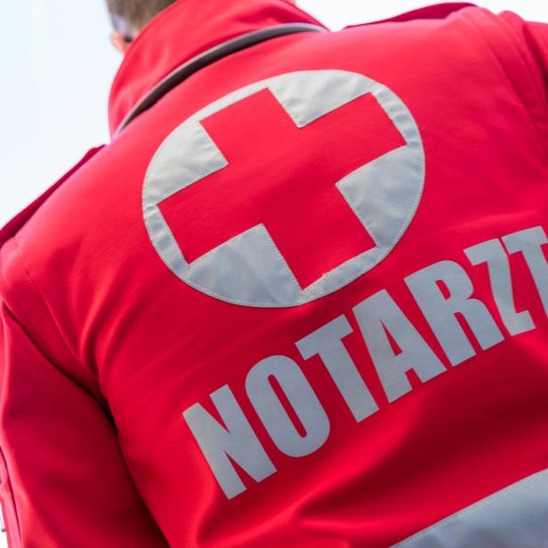 Ein roter Notarzt-Anzug mit einem weißen Kreuz ist von hinten zu sehen.