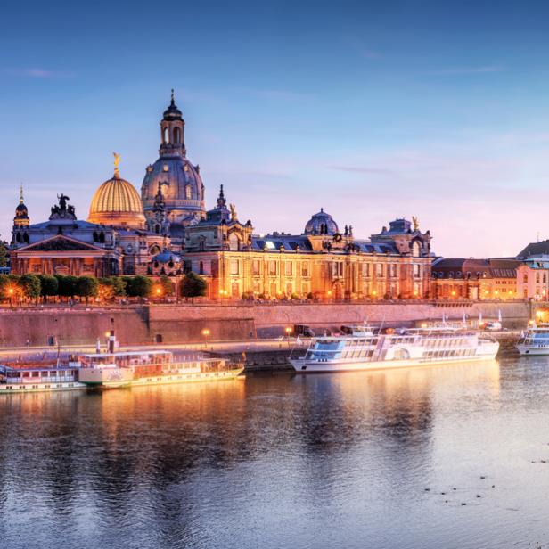 Die Altstadt einer Stadt von der anderen Seite des Flusses gesehen, in der Abenddämmerung.