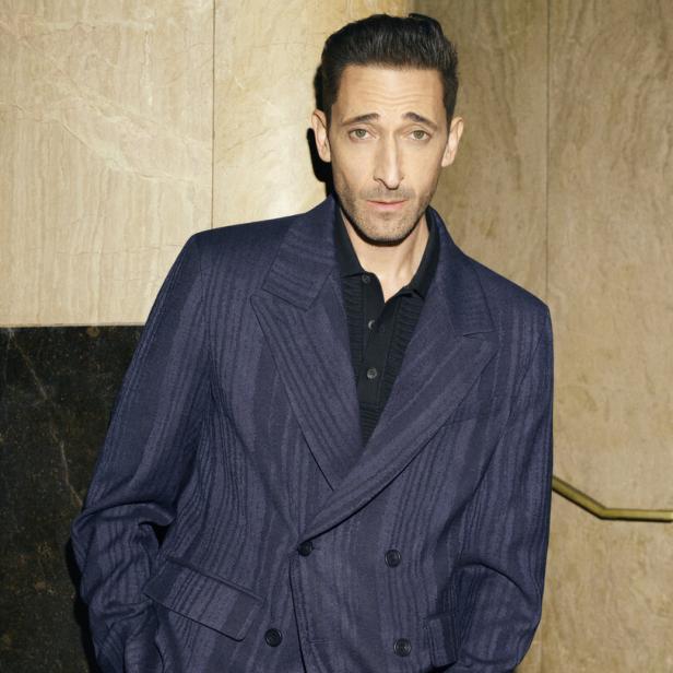 Adrien Brody trägt einen dunkelblauen Anzug.