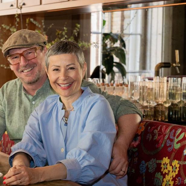 Barbara und Peter Eichberger sitzen lächelnd in einem Café.