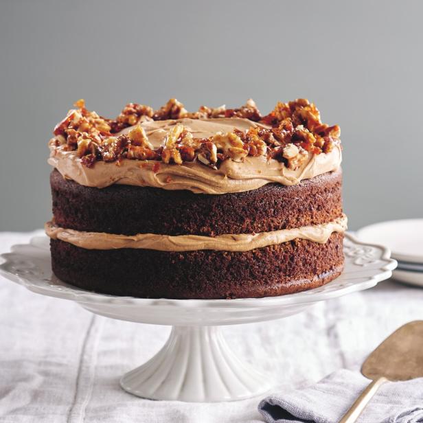 Ein Espresso-Walnuss-Kuchen auf einem weißen Tortenständer.