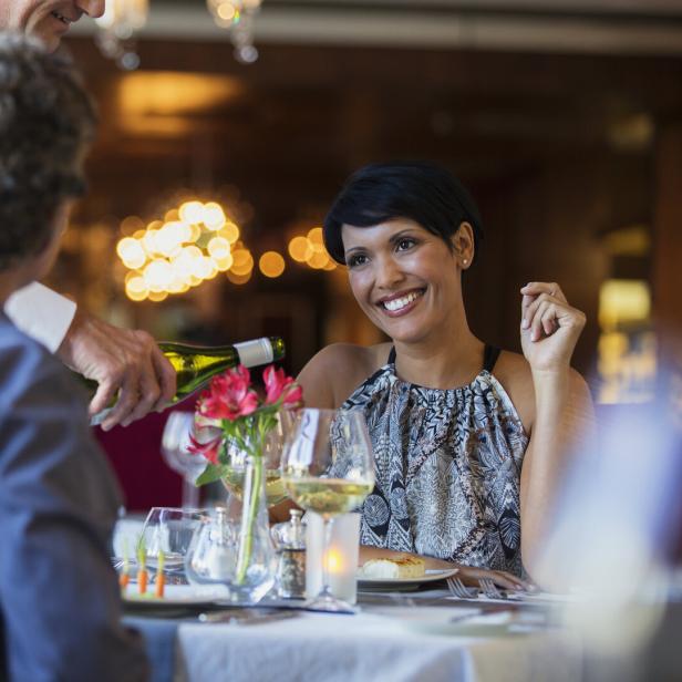 Paar genießt alkoholfreien Wein zum Essen (Symbolfoto).