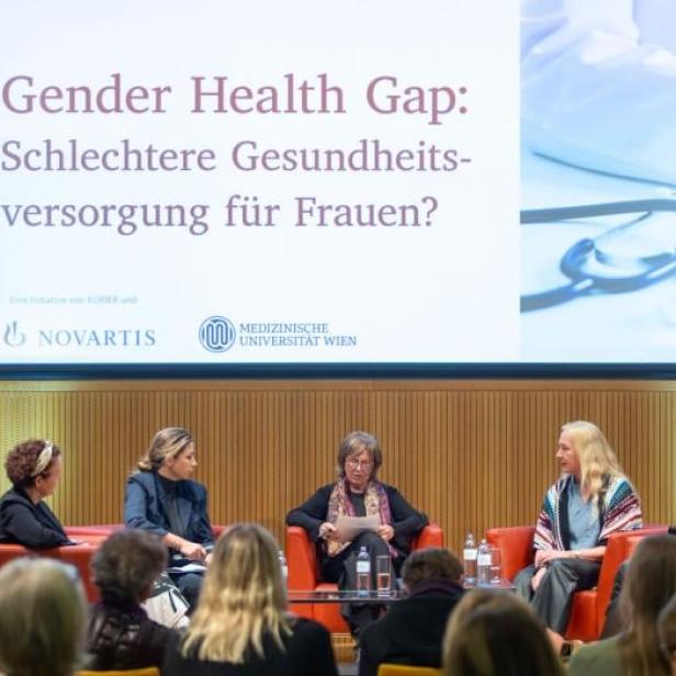Ein Panel mit fünf Frauen auf einer Bühne. Hinter ihnen eine Leinwand, auf der "Gender Health Gap: Schlechtere Gesundheitsversorgung für Frauen?" steht. 