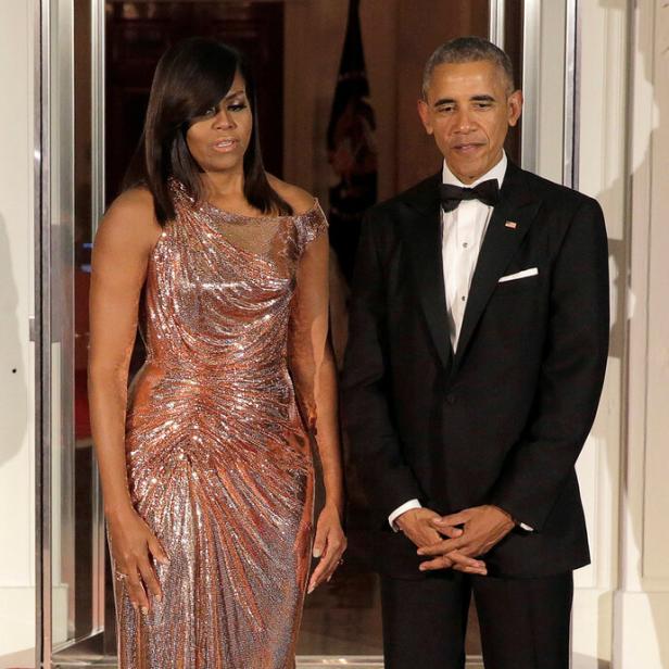Michelle und Barack Obama posieren auf einem roten Teppich.