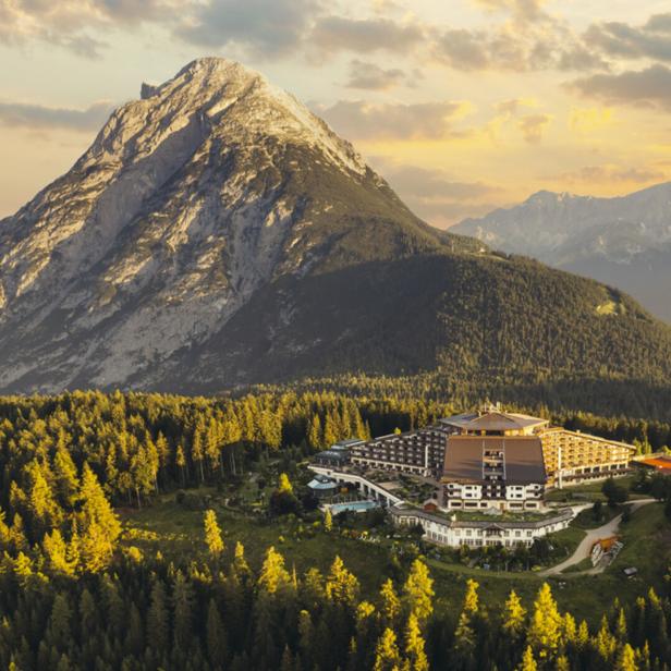 Das Interalpen-Hotel Tyrol vor einer Bergkulisse.