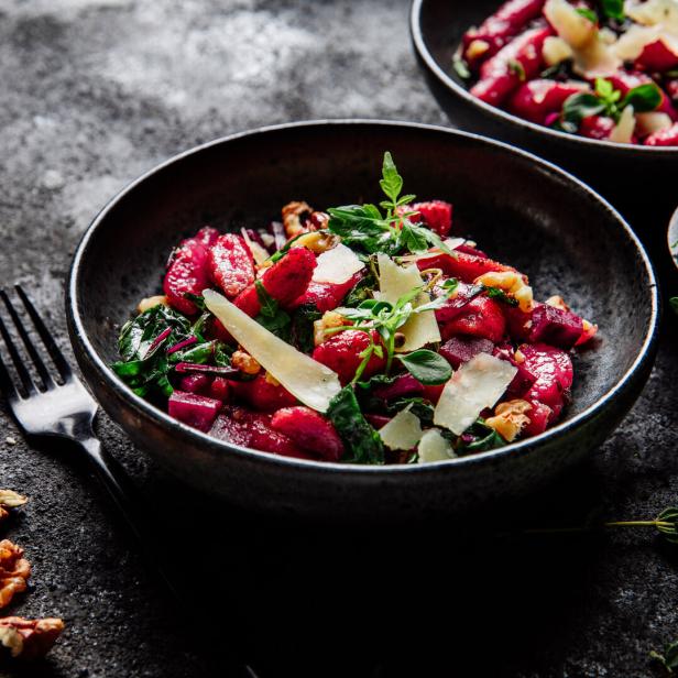 Rote Gnocchi mit Käse und Nüssen in einer Schüssel.