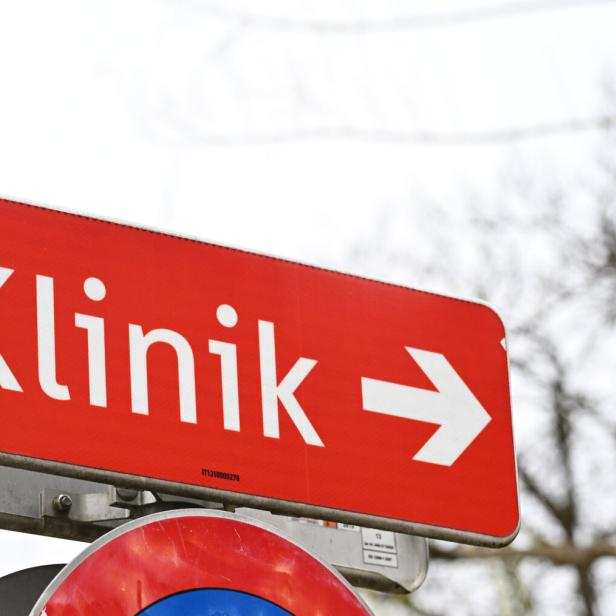 Ein rotes Hinweisschild mit weißer Aufschrift „Klinik“ und einem Pfeil nach rechts.