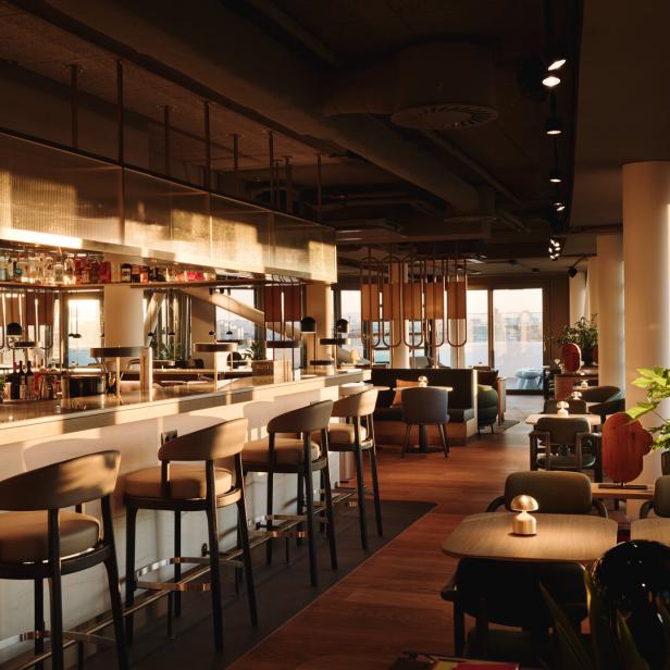 Eine Bar und ein Loungebereich in einem modern gestalteten Innenraum.
