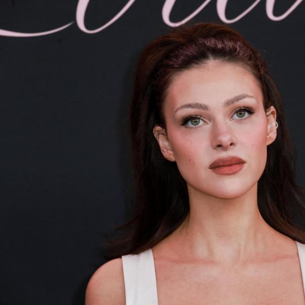 Nicola Peltz Beckham vor einem schwarzen Hintergrund.