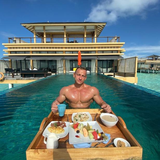 Der YouTuber vitalythegoat in einem Pool mit einem Frühstückstablett.