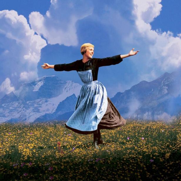Julie Andrews als Maria in dem Film „The Sound of Music“ auf einer Blumenwiese.